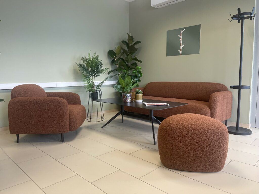 Et kontor trenger ikke å være kjedelig. Vi hjelper deg med farger, lys og layout. Bilde av moderne sofa, lyse fine vegger og blomster i fine farger. Kontor Konsult Fredrikstad